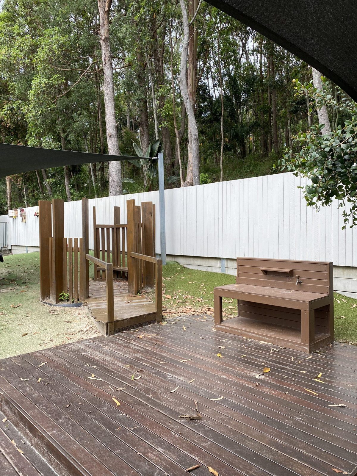 Shaded timber deck with small tables for outdoor play
