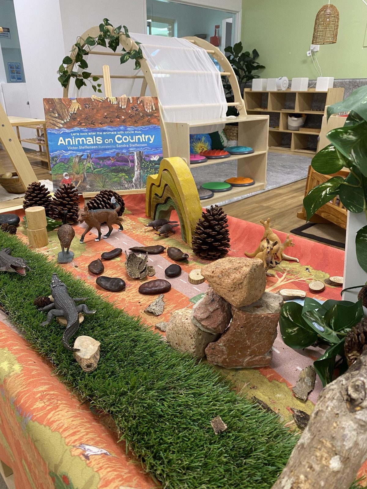 Nature play shelf with pinecones, animals and baskets