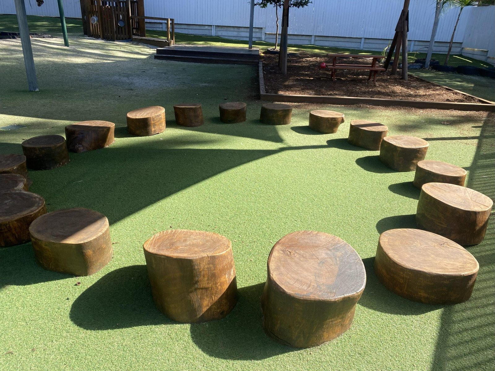 Circle of timber log seats on soft grass